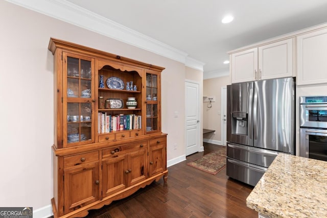 kitchen featuring dark wood-style flooring, light stone countertops, appliances with stainless steel finishes, recessed lighting, and ornamental molding