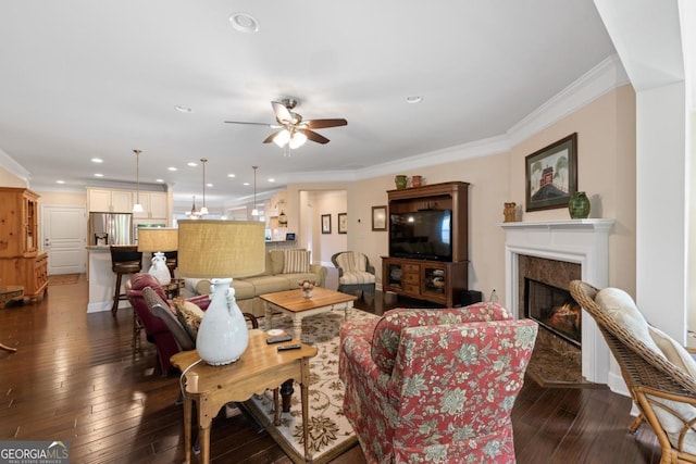 living area featuring crown molding, a high end fireplace, ceiling fan, and dark wood-style flooring