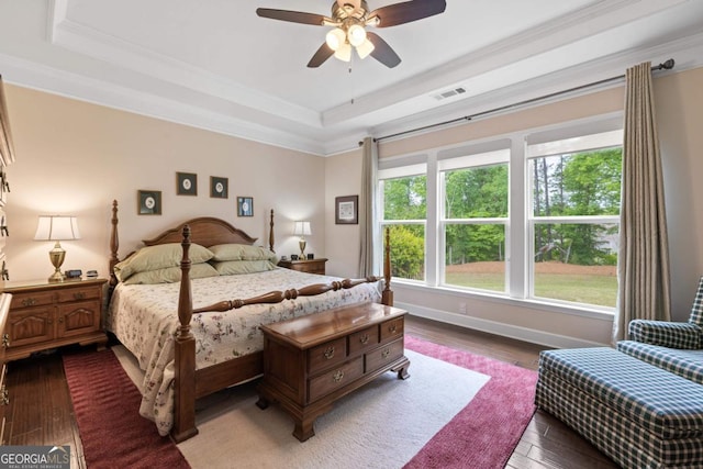 bedroom with visible vents, ornamental molding, dark wood-type flooring, and a tray ceiling