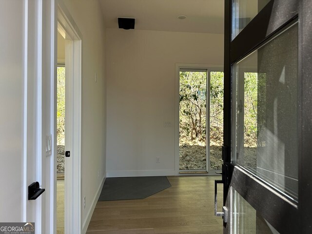 doorway to outside with baseboards and wood finished floors