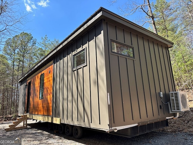 view of property exterior with board and batten siding and ac unit
