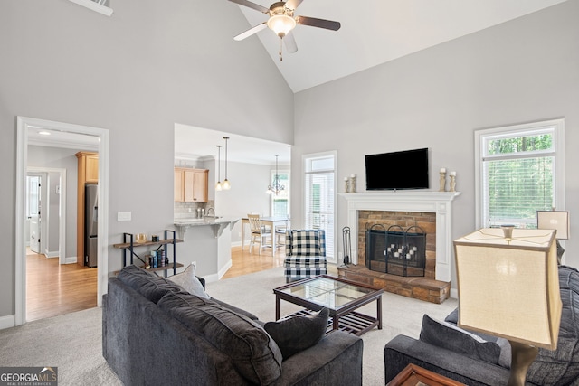68 Timber Creek Estates Dr, Sharpsburg, GA 30277 - living room featuring ceiling fan, light carpet, high vaulted ceiling, a stone fireplace, and baseboards