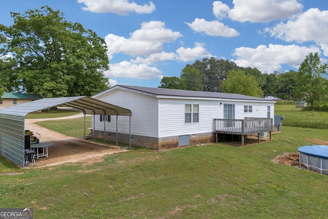 187 New Hope Rd, Canon, GA 30520 - rear view of house with a detached carport, dirt driveway, crawl space, metal roof, and a lawn