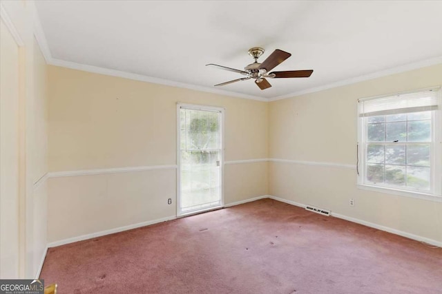 carpeted spare room featuring ornamental molding, baseboards, and ceiling fan