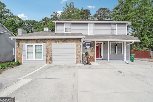 5022 Audubon Pl, Norcross, GA 30093 - traditional-style house with a porch, a chimney, fence, concrete driveway, and stone siding