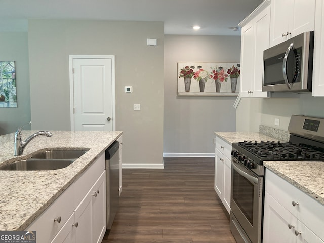 kitchen featuring baseboards, dark wood-style floors, recessed lighting, a sink, and stainless steel appliances