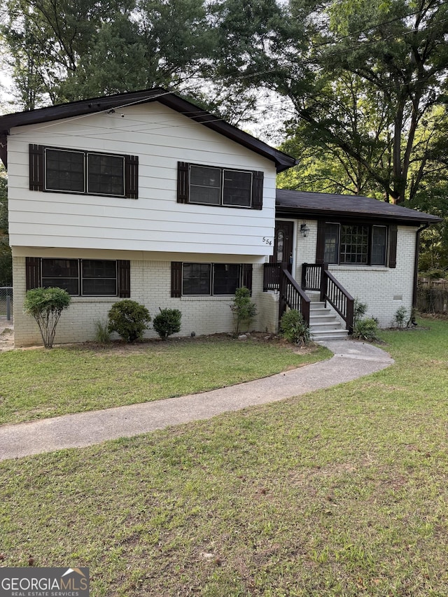 tri-level home with a front yard and brick siding
