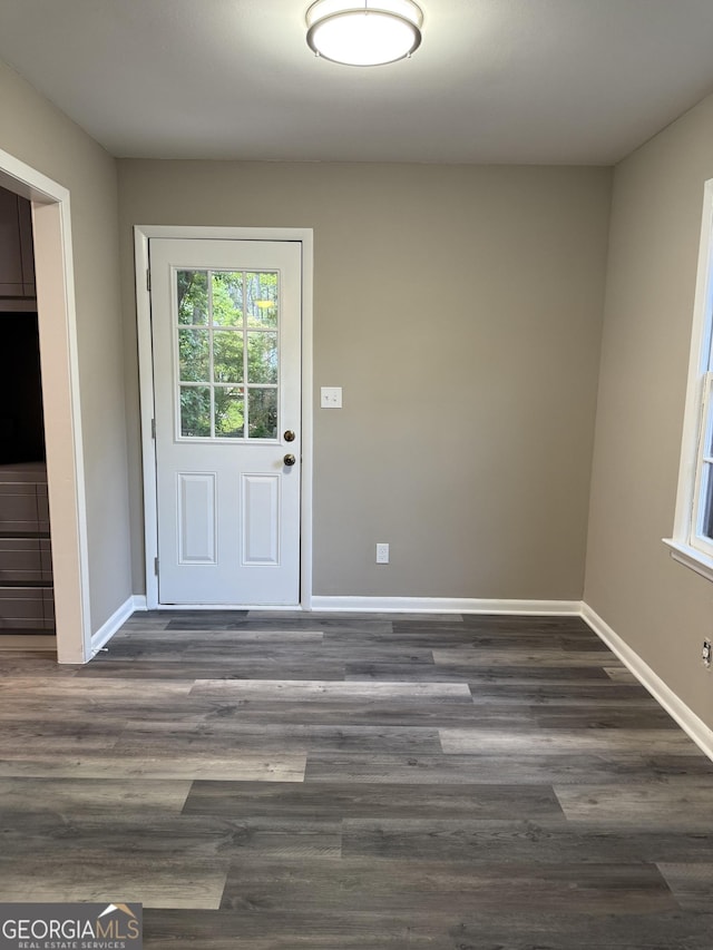 doorway with baseboards and dark wood finished floors