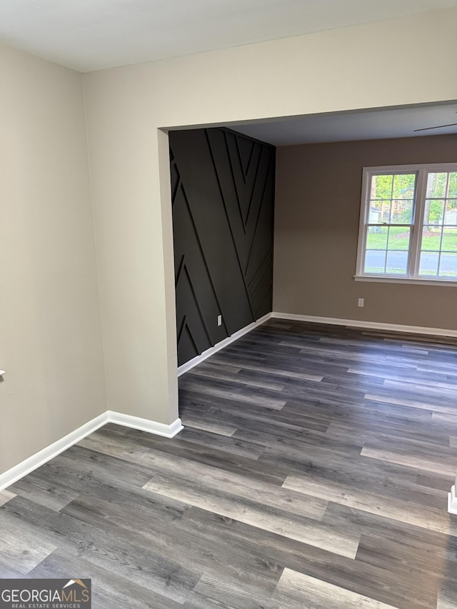 empty room featuring baseboards and wood finished floors