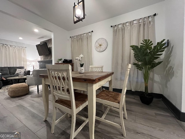 1074 Hobson St, Atlanta, GA 30310 - dining room featuring light wood-style floors, baseboards, a fireplace, and recessed lighting