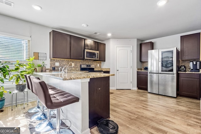 400 Toronto Cir, Hampton, GA 30228 - kitchen with appliances with stainless steel finishes, tasteful backsplash, dark brown cabinets, and visible vents