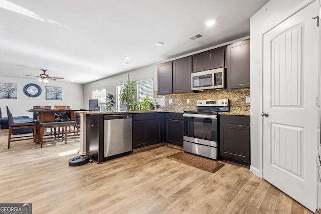 400 Toronto Cir, Hampton, GA 30228 - kitchen featuring visible vents, light wood-type flooring, tasteful backsplash, light stone counters, and stainless steel appliances