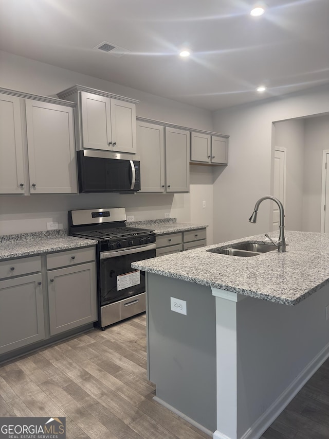 1155 Park Center Cir NW, Austell, GA 30168 - kitchen with appliances with stainless steel finishes, a sink, light wood-style floors, gray cabinets, and recessed lighting