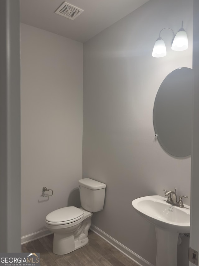1155 Park Center Cir NW, Austell, GA 30168 - half bathroom featuring toilet, baseboards, visible vents, and wood finished floors