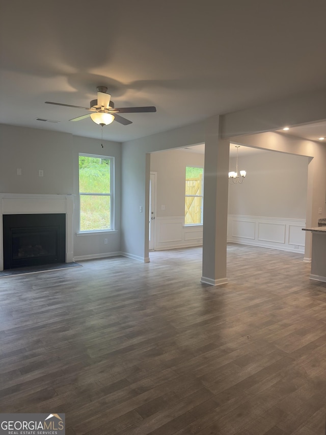 1155 Park Center Cir NW, Austell, GA 30168 - unfurnished living room featuring a fireplace with flush hearth, a decorative wall, ceiling fan with notable chandelier, and dark wood-style flooring