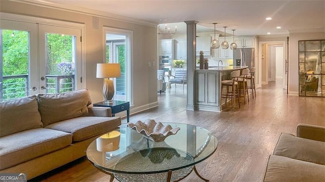 living area featuring french doors, recessed lighting, baseboards, wood finished floors, and ornamental molding