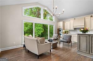 8190 Old Mill Dr, Gainesville, GA 30506 - living room featuring a chandelier, dark wood finished floors, high vaulted ceiling, and baseboards