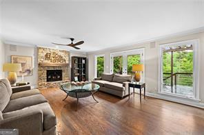 8190 Old Mill Dr, Gainesville, GA 30506 - living room with healthy amount of natural light, ceiling fan, a large fireplace, wood finished floors, and ornamental molding