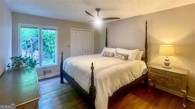 bedroom featuring baseboards, a ceiling fan, wood finished floors, and multiple windows