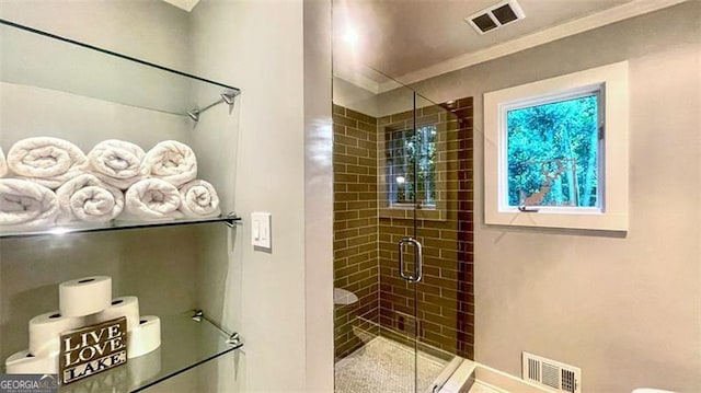 full bath with ornamental molding, a shower stall, and visible vents