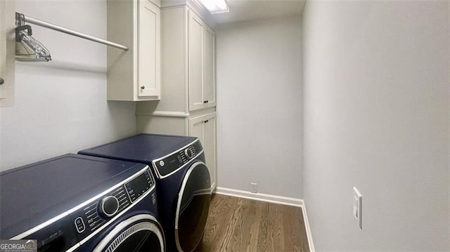washroom featuring cabinet space, separate washer and dryer, baseboards, and dark wood-style flooring
