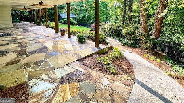 view of patio featuring ceiling fan and fence