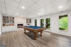 8190 Old Mill Dr, Gainesville, GA 30506 - game room featuring wood finished floors, a large fireplace, built in shelves, billiards table, and baseboards
