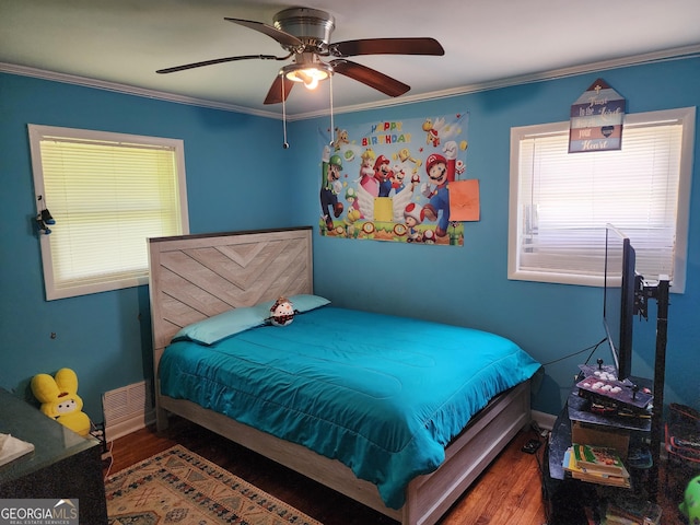 bedroom featuring crown molding, ceiling fan, wood finished floors, and visible vents