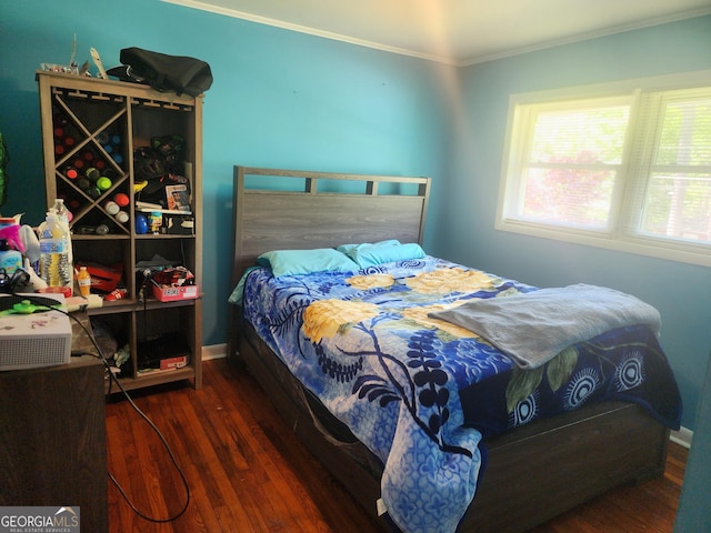 bedroom with baseboards, ornamental molding, and wood finished floors