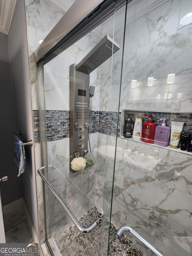 bathroom with baseboards, marble finish floor, and a stall shower