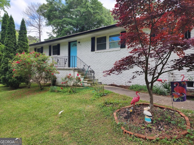 view of front facade featuring brick siding and a front yard