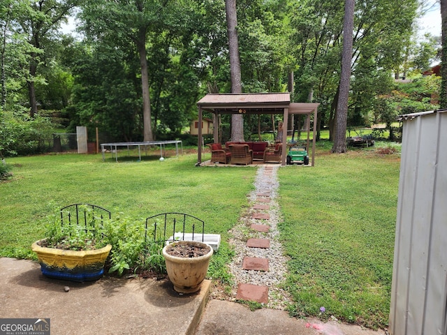view of yard with a trampoline, a gazebo, and outdoor lounge area