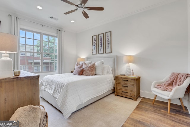 bedroom featuring light wood-type flooring, recessed lighting, crown molding, baseboards, and a ceiling fan