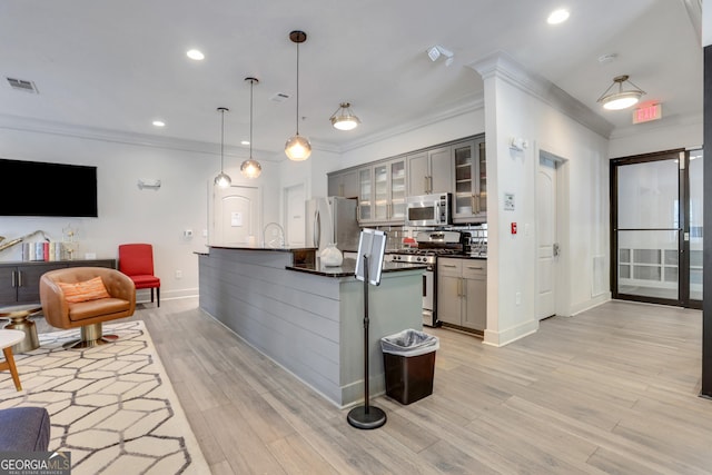 kitchen with appliances with stainless steel finishes, dark countertops, gray cabinets, crown molding, and baseboards