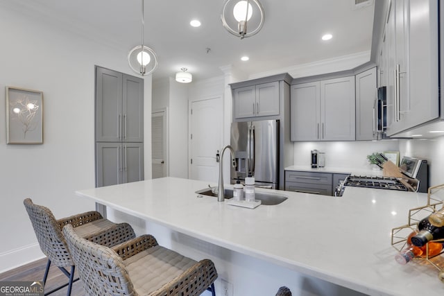 kitchen with gray cabinets, appliances with stainless steel finishes, a sink, ornamental molding, and recessed lighting