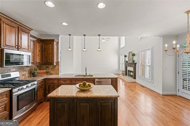 4876 Sara Creek Way, Sugar Hill, GA 30518 - kitchen with an inviting chandelier, light stone counters, a sink, stainless steel appliances, and a peninsula