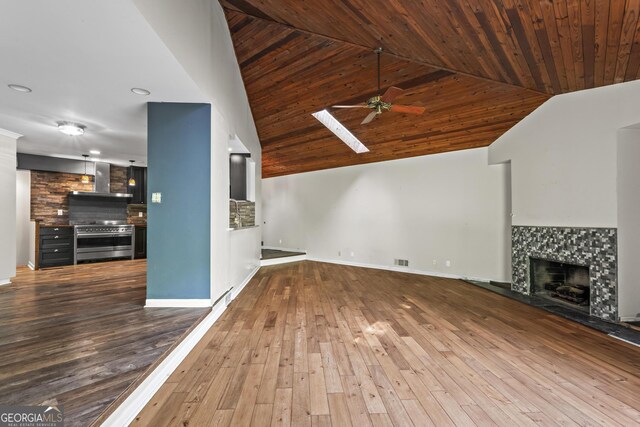 unfurnished living room with ceiling fan, visible vents, a tiled fireplace, wooden ceiling, and wood-type flooring