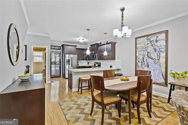 1365 Memorial Dr SE Unit # 12, Atlanta, GA 30317 - dining area with crown molding, light wood finished floors, a chandelier, and baseboards