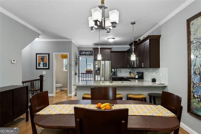 1365 Memorial Dr SE Unit # 12, Atlanta, GA 30317 - dining room with light wood finished floors, a chandelier, crown molding, and baseboards