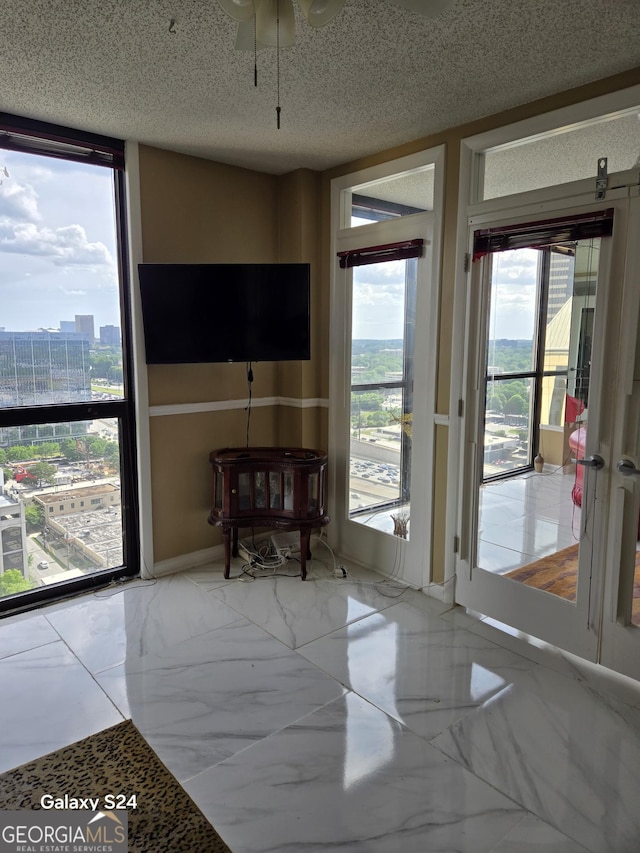 1280 W Peachtree St NW Apt 2606, Atlanta, GA 30309 - interior space featuring baseboards, plenty of natural light, ceiling fan, and marble finish floor