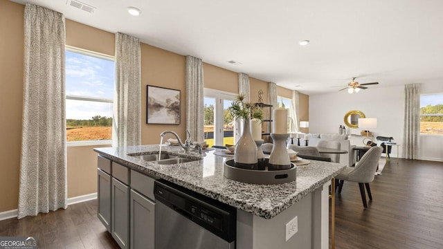 252 Kennelsman Dr, Griffin, GA 30224 - kitchen featuring dark wood-style flooring, a sink, baseboards, stainless steel dishwasher, and a center island with sink