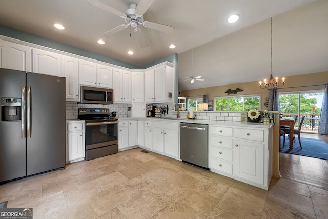 945 Sandy Run Dr, Sparta, GA 31087 - kitchen with ceiling fan with notable chandelier, stone tile floors, stainless steel appliances, a peninsula, and decorative backsplash