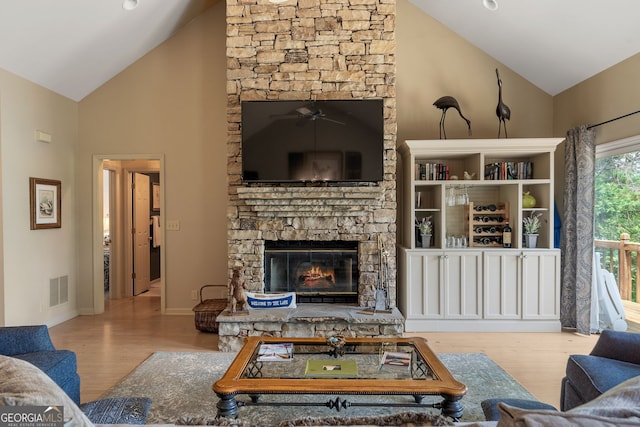 945 Sandy Run Dr, Sparta, GA 31087 - living area featuring visible vents, wood finished floors, a stone fireplace, ceiling fan, and high vaulted ceiling