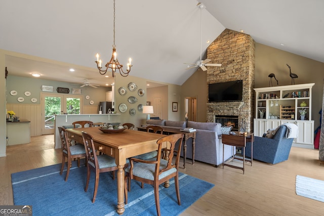 945 Sandy Run Dr, Sparta, GA 31087 - dining room featuring light wood finished floors, ceiling fan with notable chandelier, a fireplace, and high vaulted ceiling