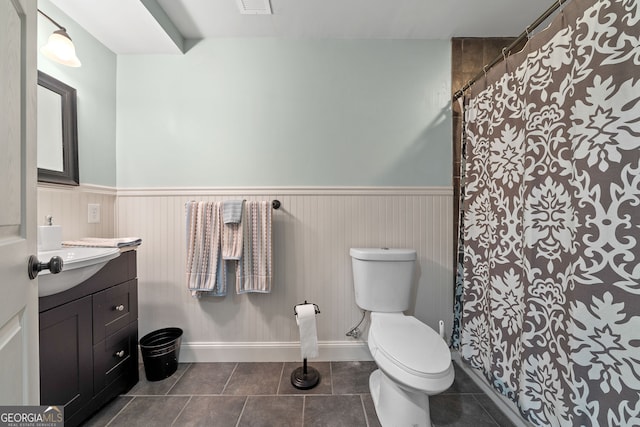 945 Sandy Run Dr, Sparta, GA 31087 - bathroom featuring tile patterned flooring, vanity, toilet, a wainscoted wall, and curtained shower