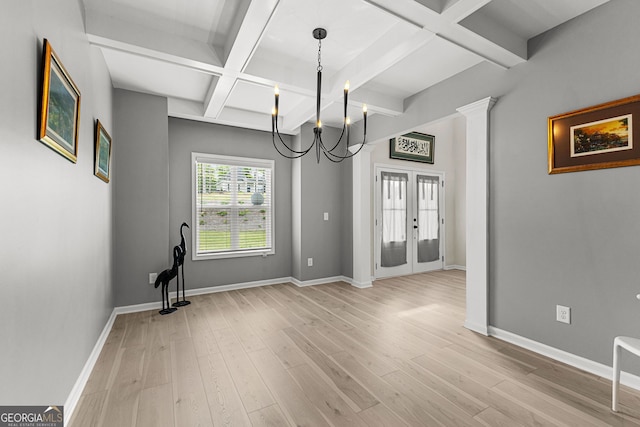 unfurnished dining area with an inviting chandelier, baseboards, light wood-type flooring, french doors, and coffered ceiling