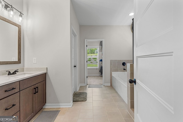 bathroom with baseboards, tile patterned floors, a bath, and vanity