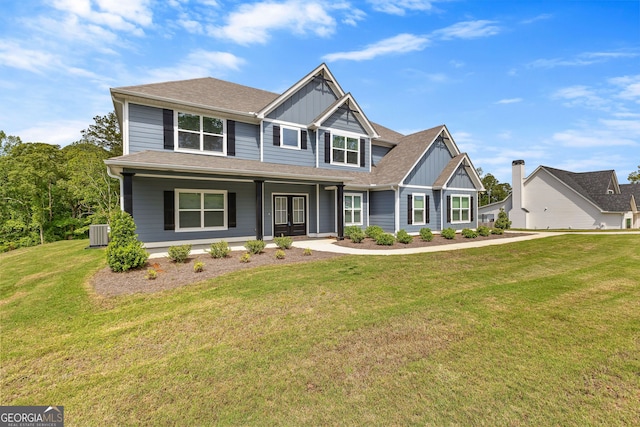 craftsman house with board and batten siding, a porch, roof with shingles, cooling unit, and a front lawn