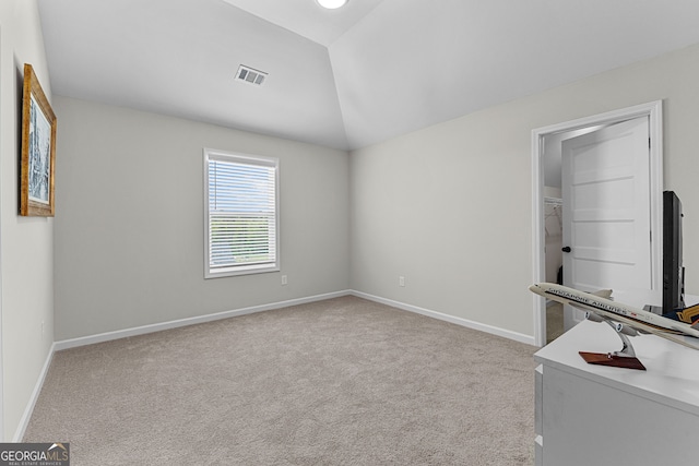 unfurnished room with visible vents, baseboards, carpet, and lofted ceiling