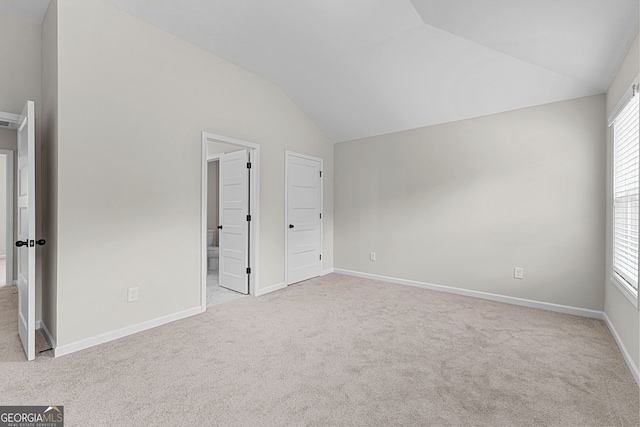 unfurnished bedroom with baseboards, vaulted ceiling, and carpet flooring